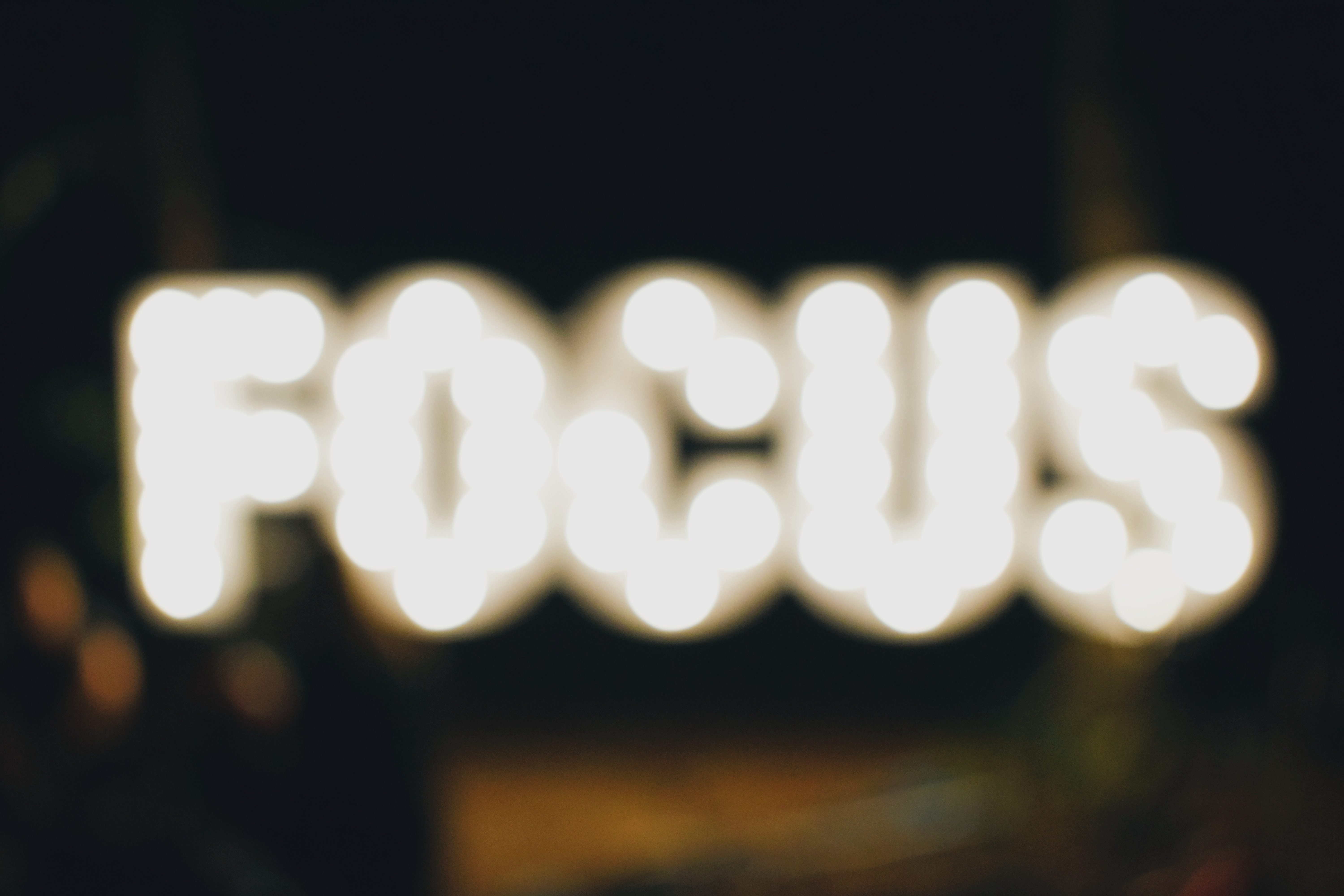 Blurry white text on black background that says "FOCUS"