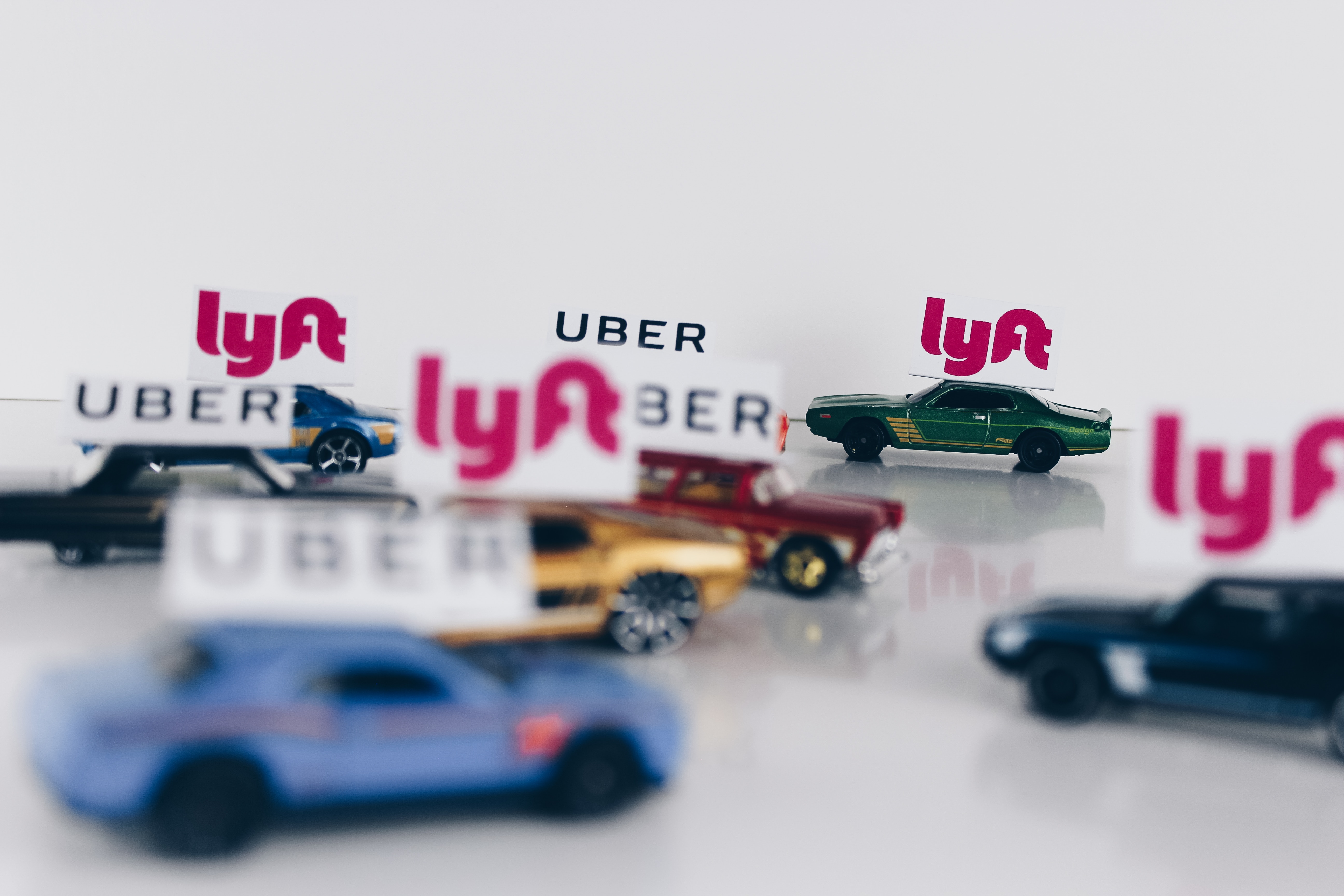 Image of toy Uber and Lyft cars driving around