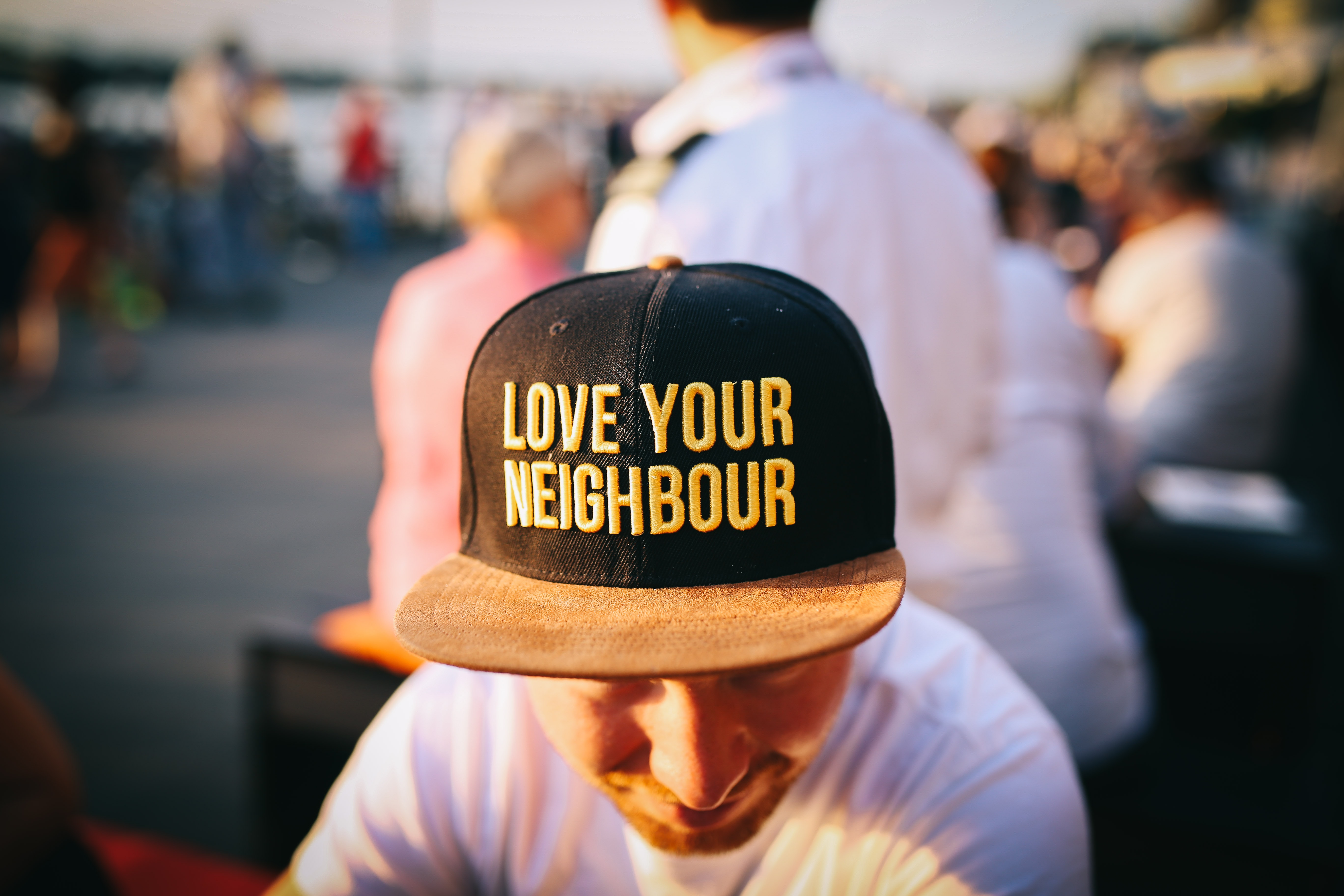 Man wearing hat that says "Love Your Neighbour"